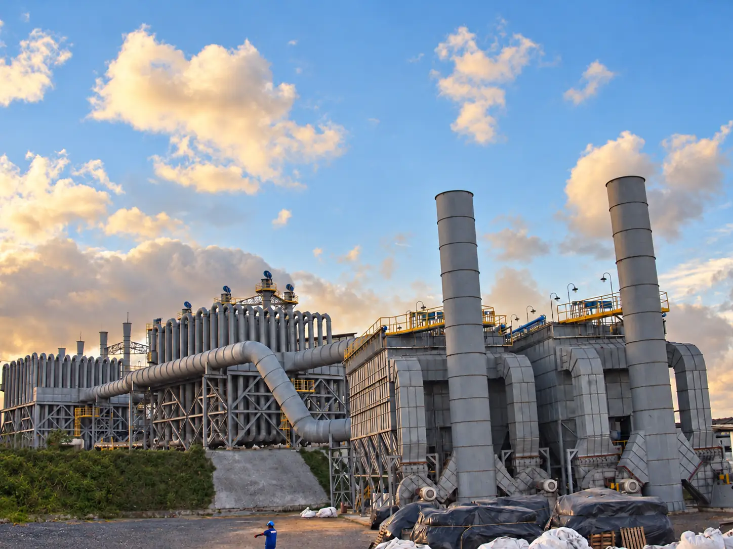 Overview of an industrial installation with tubular equipment, filters, ducts, and stacks