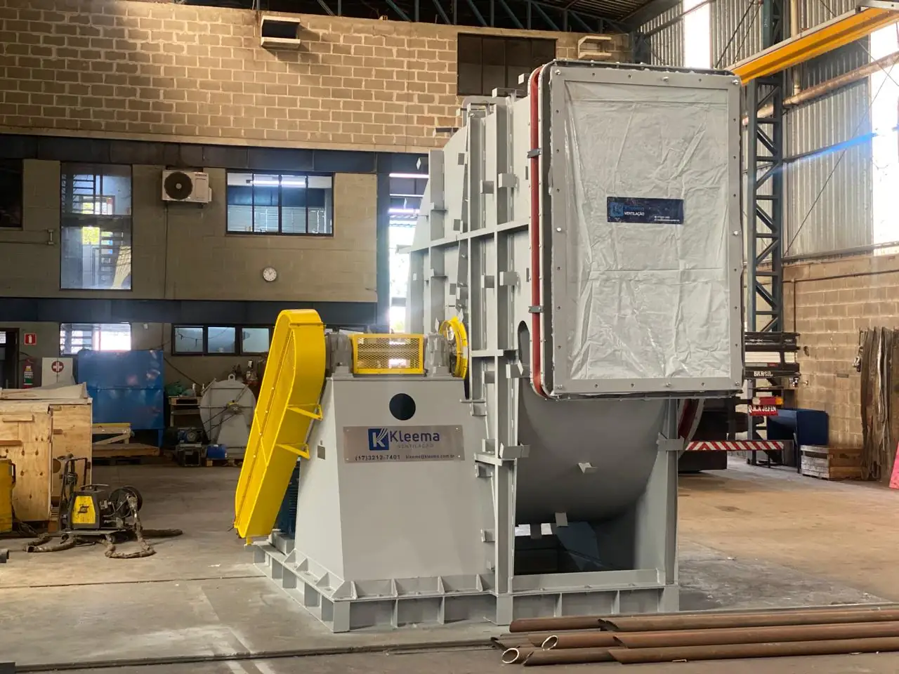 Gray centrifugal fan with yellow drive guard, manufactured by Kleema